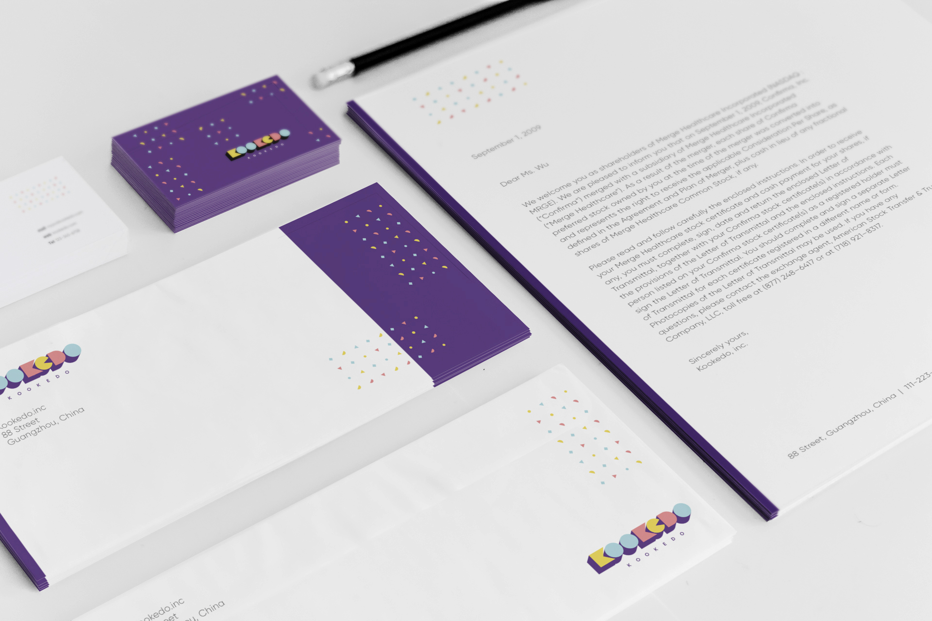 Kookedo stationery — business cards, letterhead, and envelopes on a desk